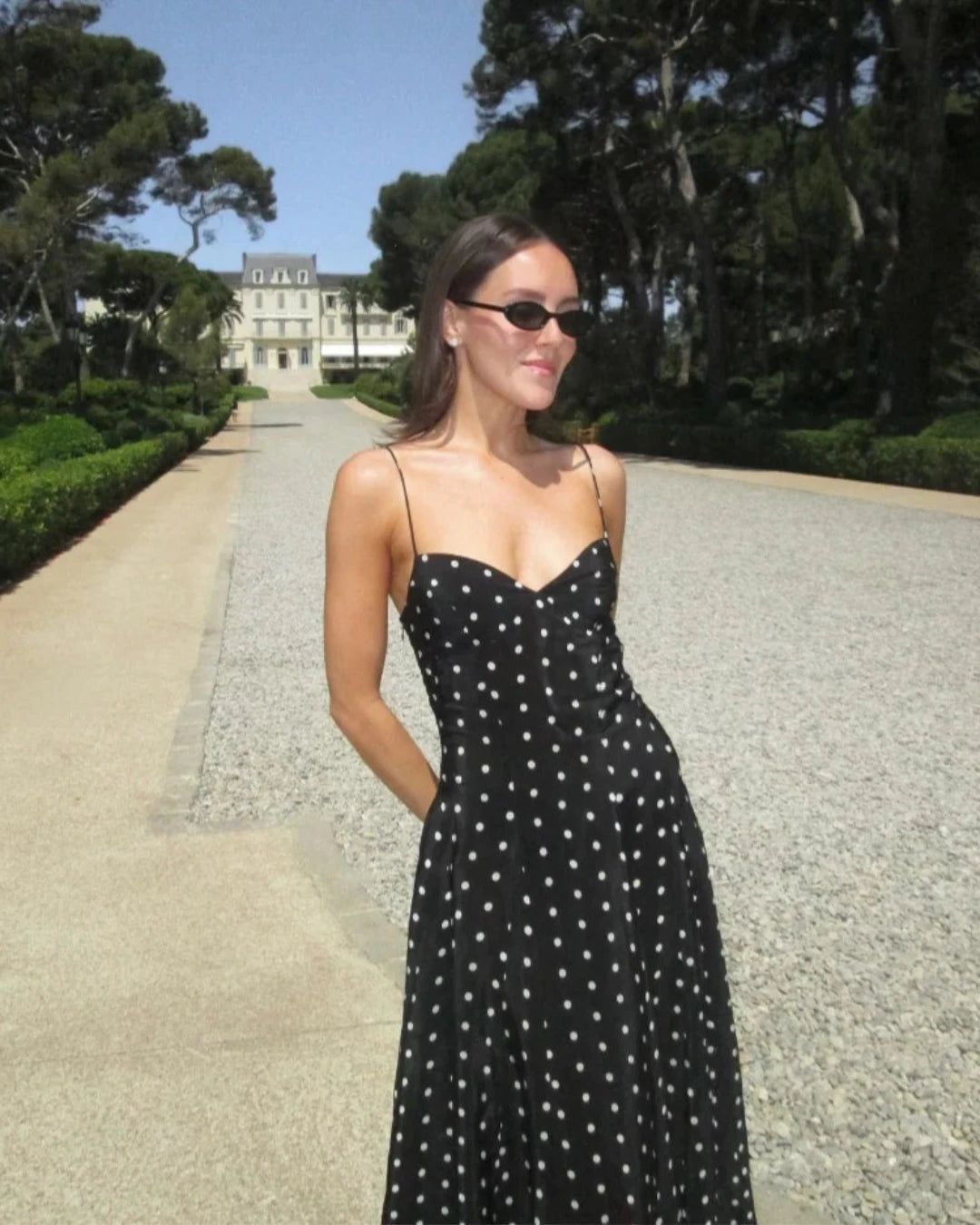 Robe Léontine noire à pois, longueur cheville et bretelles fines pour un look raffiné.